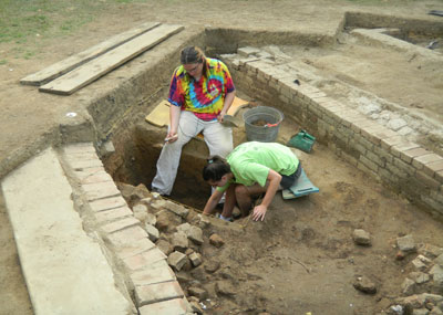 Thomas Barry and Marissa Parlock excavate the test unit in the brick cellar.