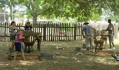 Students excavate units outside the reconstructed fence of the Calvert House site.