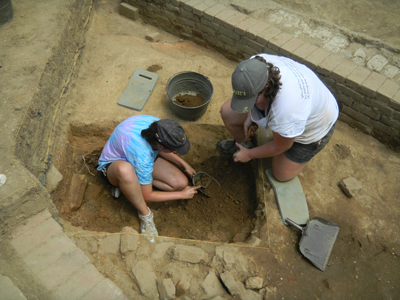  Marissa Parlock and Jaimie Wilder excavate the test unit in the brick cellar.