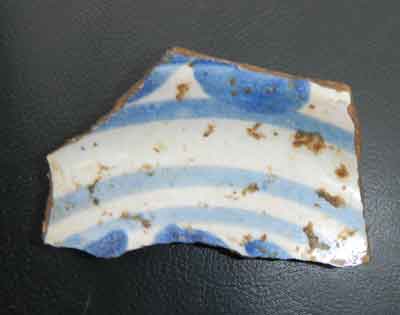 Part of a tin glazed earthenware plate recovered from the plaster fill in the cellar.