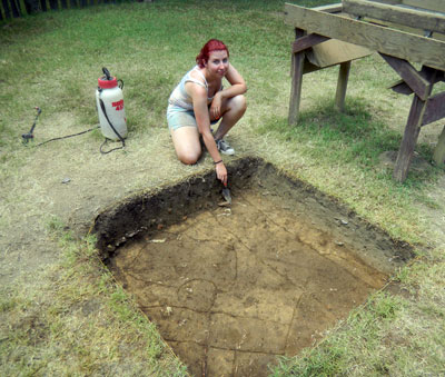Katharine Wade points to a newly discovered fence line in the unit.