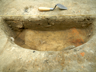 Cross-section of circular intrusion with burned clay wall to the right.