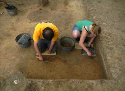 Jacob Griffith-Rosenberg and Catherine Dye clean the floor of a recently excavated unit.